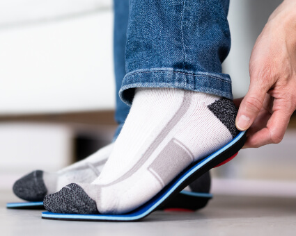 Man adjusting orthotics