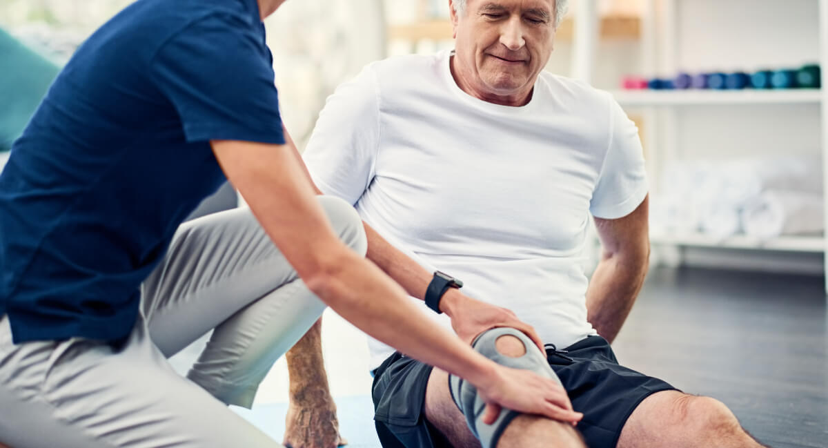 Physio adjusting patient's knee guard