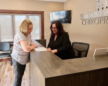 Patient discussing paperwork with receptionist