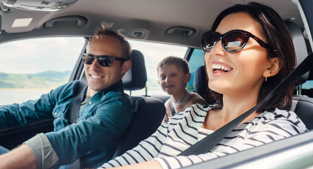 Smiling family sitting in a car