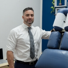 Dr William standing next to adjustment table
