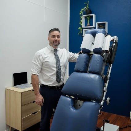 Chiropractor standing next to adjustment table