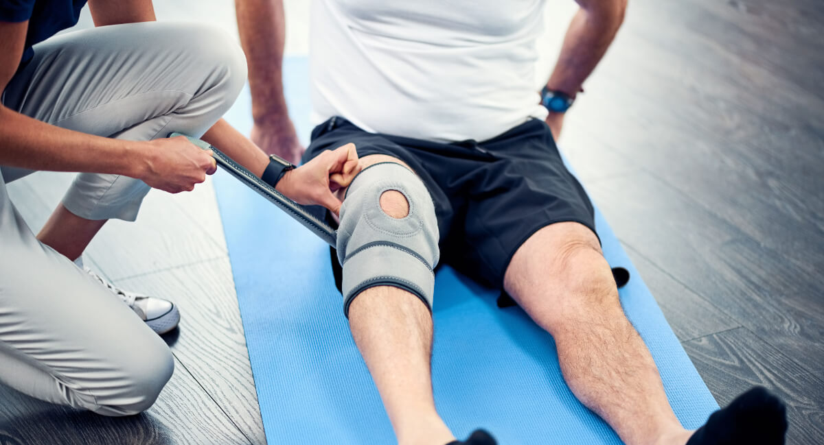 Physical therapist treating patient's knee