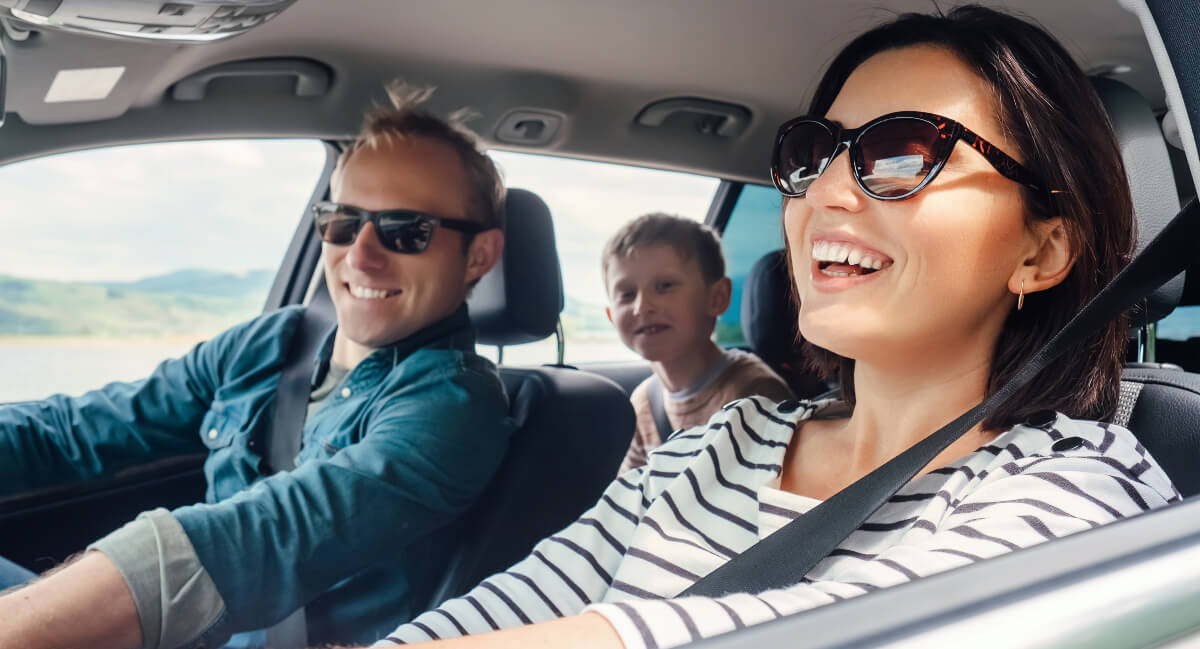 Smiling family sitting in a car