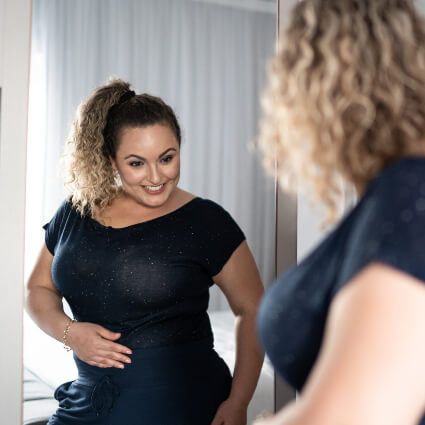Smiling woman looking at self in a mirror