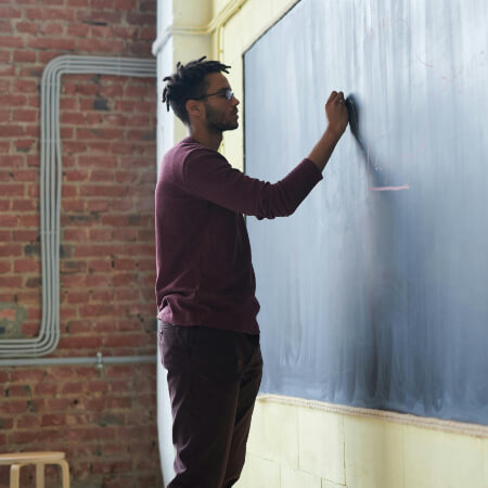Teacher writing on chalkboard