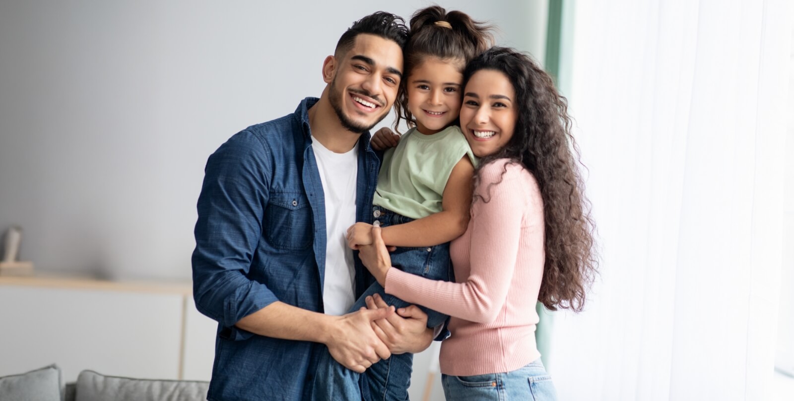 Mom, dad, and young girl posing for a photo