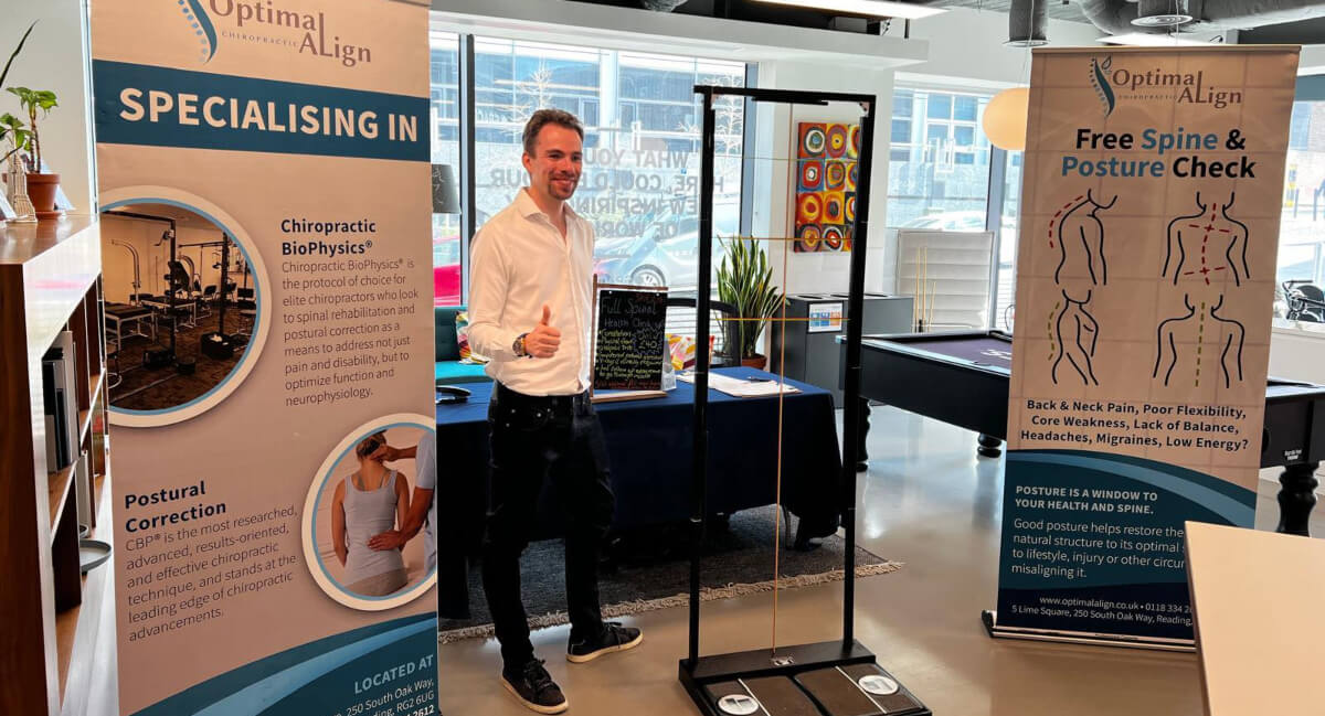 Chiropractor standing in office interior and giving a thumbs-up
