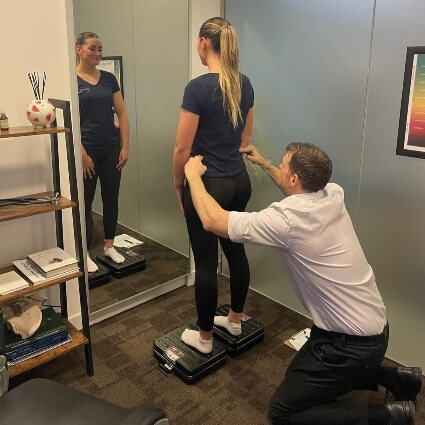 Chiropractor assessing patient's back