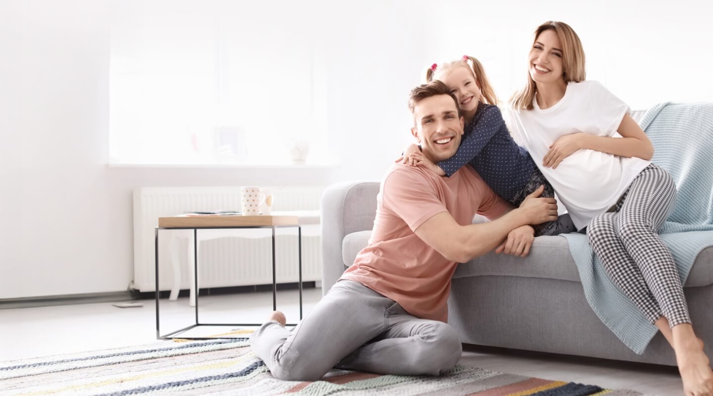 Smiling family of three in a living room