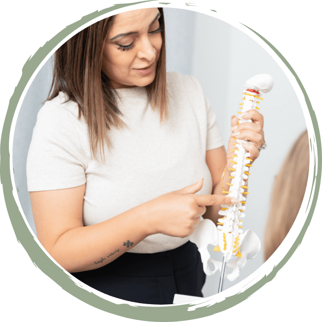 South Surrey Chiropractor Dr. Robin Randhawa holding spine model