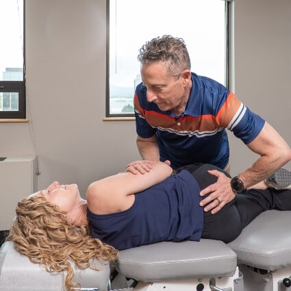 Dr Glenn adjusting patients back