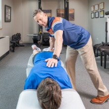 Dr. Glenn adjusting patients back