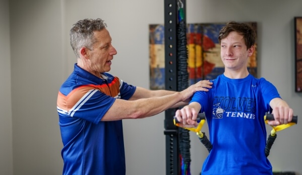 Denver chiropractor Dr. Glenn helping patient to work out