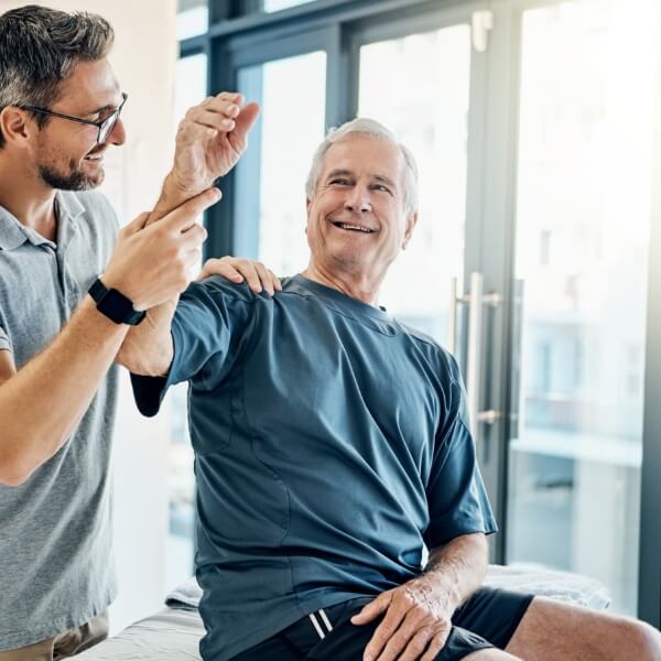Chiropractor stretching male patient's arm