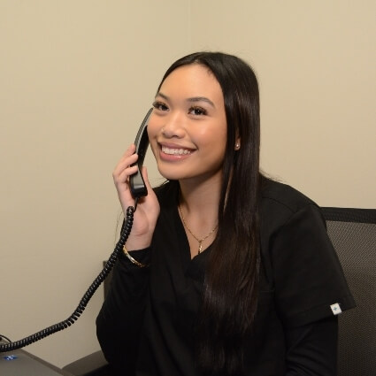 front desk staff smiling and answering phone