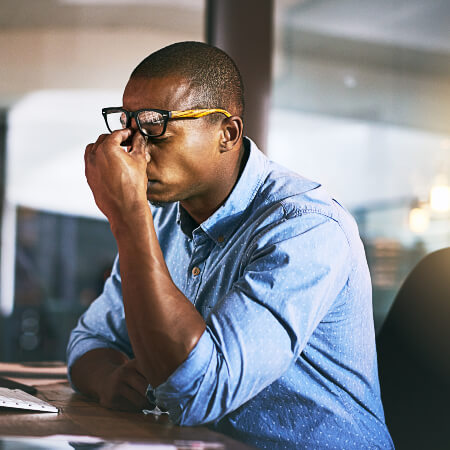Man sitting at desk experiencing discomfort