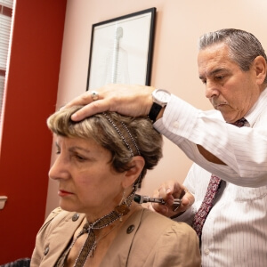 Dr. James using activator on woman's neck