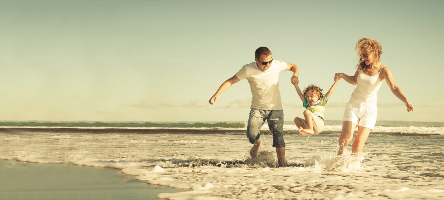 family of 3 playing on the beach