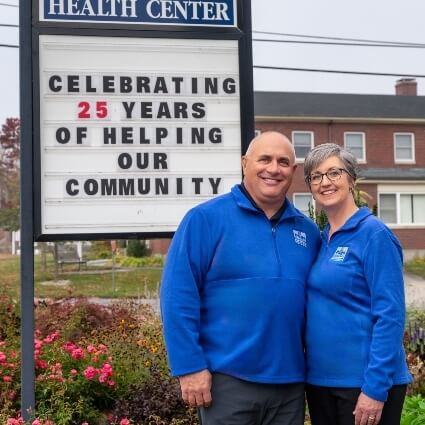 Page Chiropractic Health Center team smiling in front of our sign