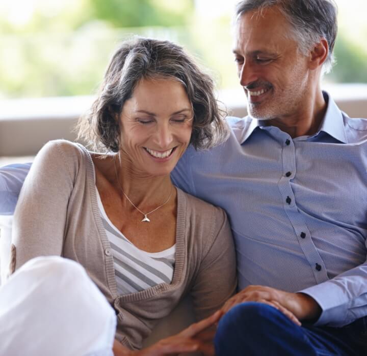 couple smiling and sitting on couch