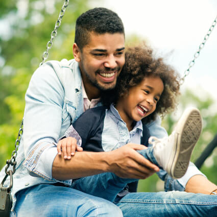 Dad and young daughter on swing