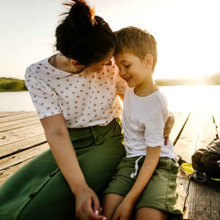 Mom and young son sitting at the pier