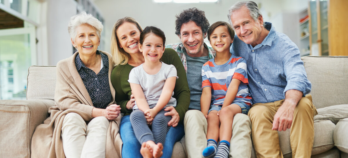 Smiling multi-gen family sitting on a couch