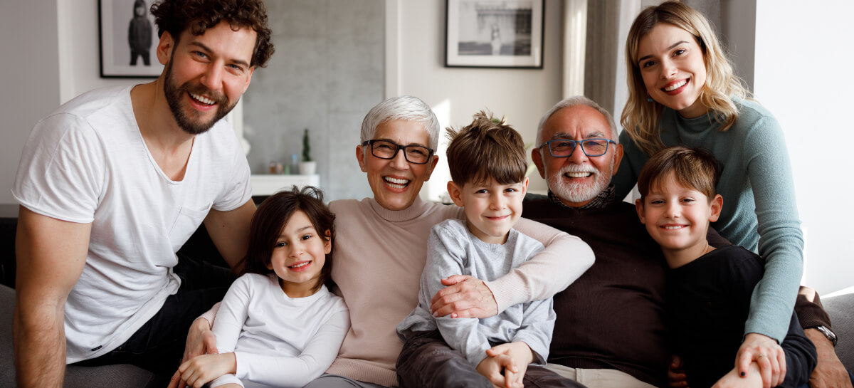 Smiling multi-gen family sitting on a couch
