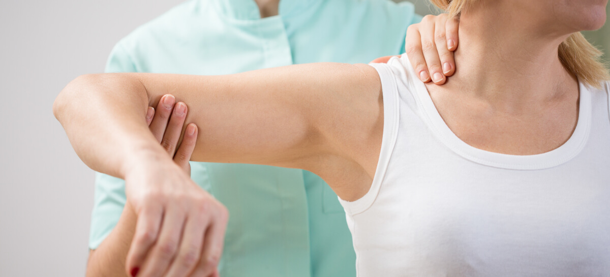 Female chiropractor adjusting patient's arm