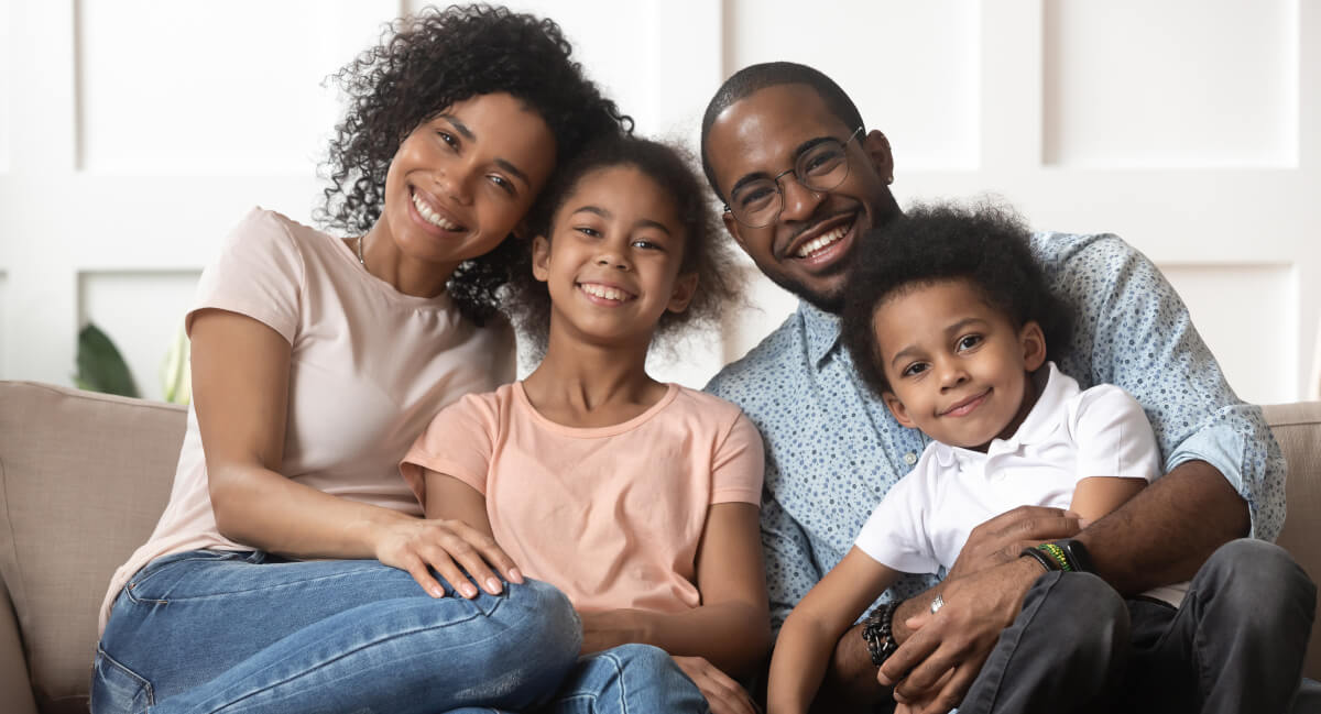 Family of four sitting on couch