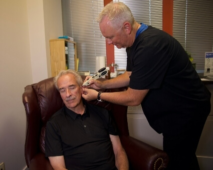 Applying acupuncture device to ear