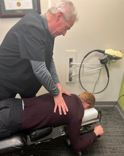 Calgary Chiropractor Dr. Stewart adjusting patients back