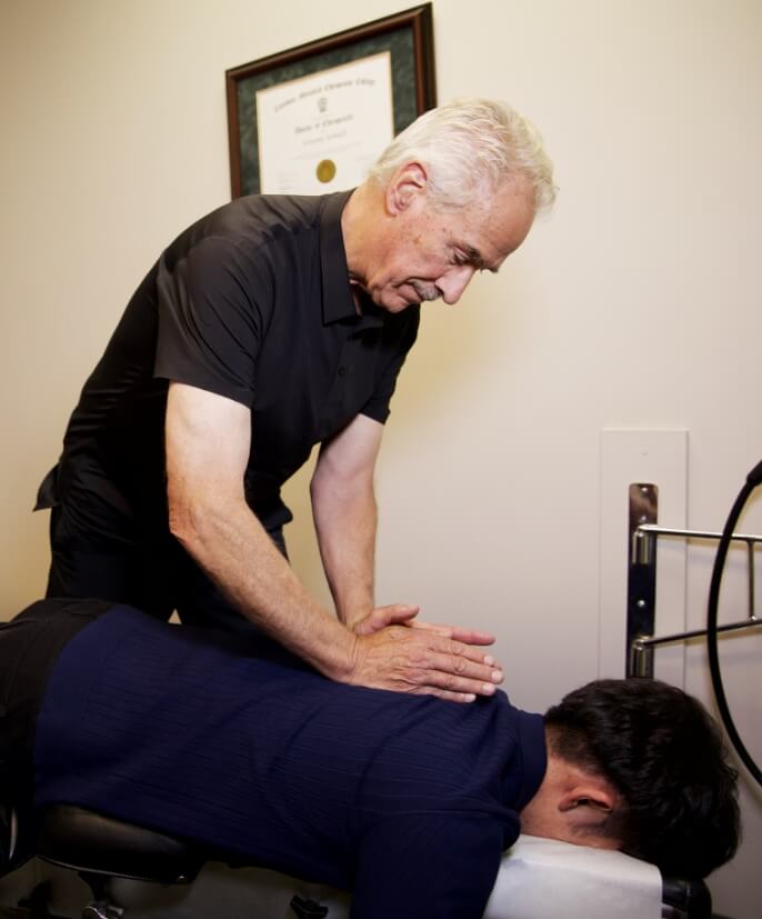 Chiropractor checking patients ear