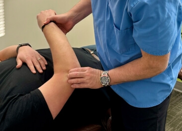 Chiropractor touching patients elbow
