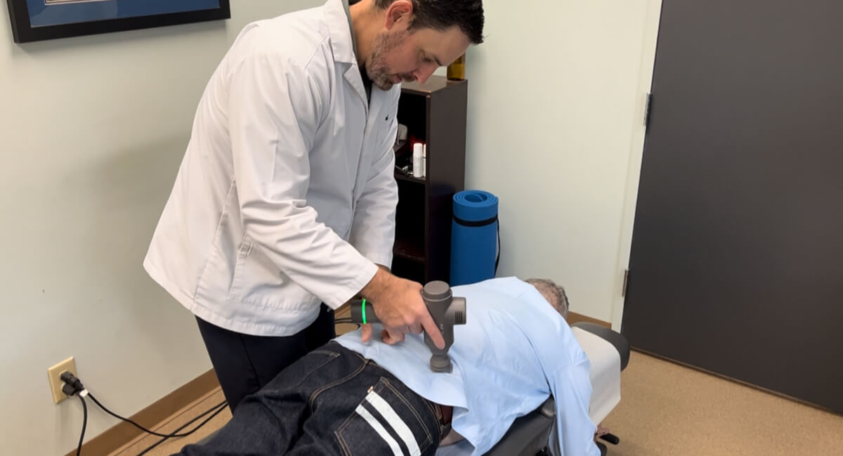 Chapel Hill chiropractor using tool to adjust patient