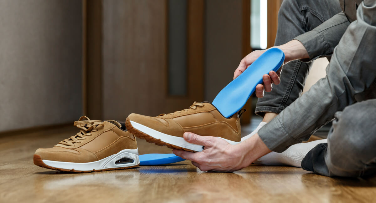 Man placing orthotics into shoes