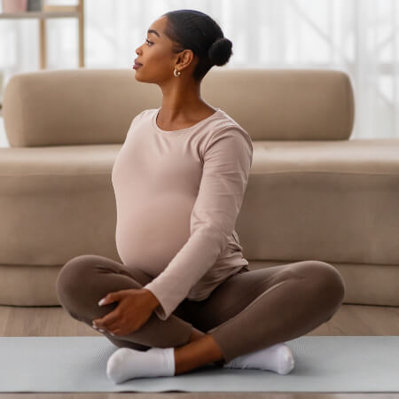 Pregnant woman sitting on a carpet