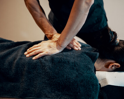 Male chiropractor giving a back adjustment