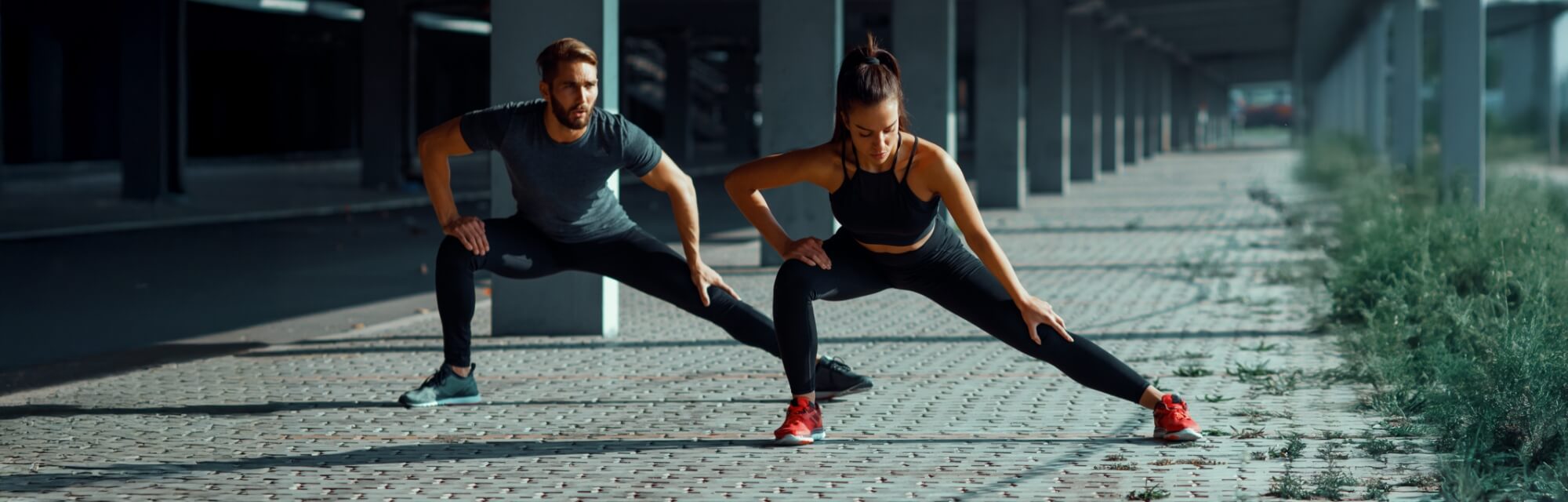 Athletic man and woman stretching their bodies