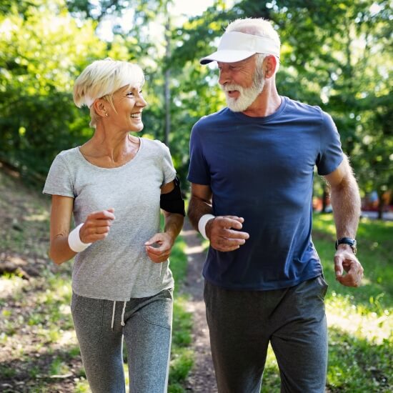 two mature people running outdoors