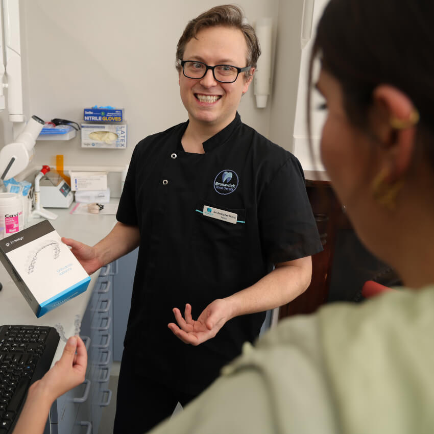 Brunswick dentist Dr Chris tlaking with a patient about invisalign