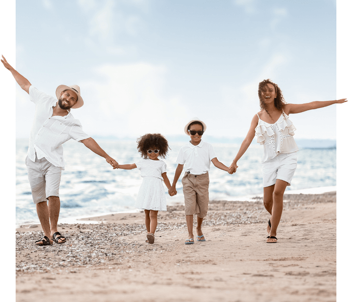 family of 4 walking on the beach