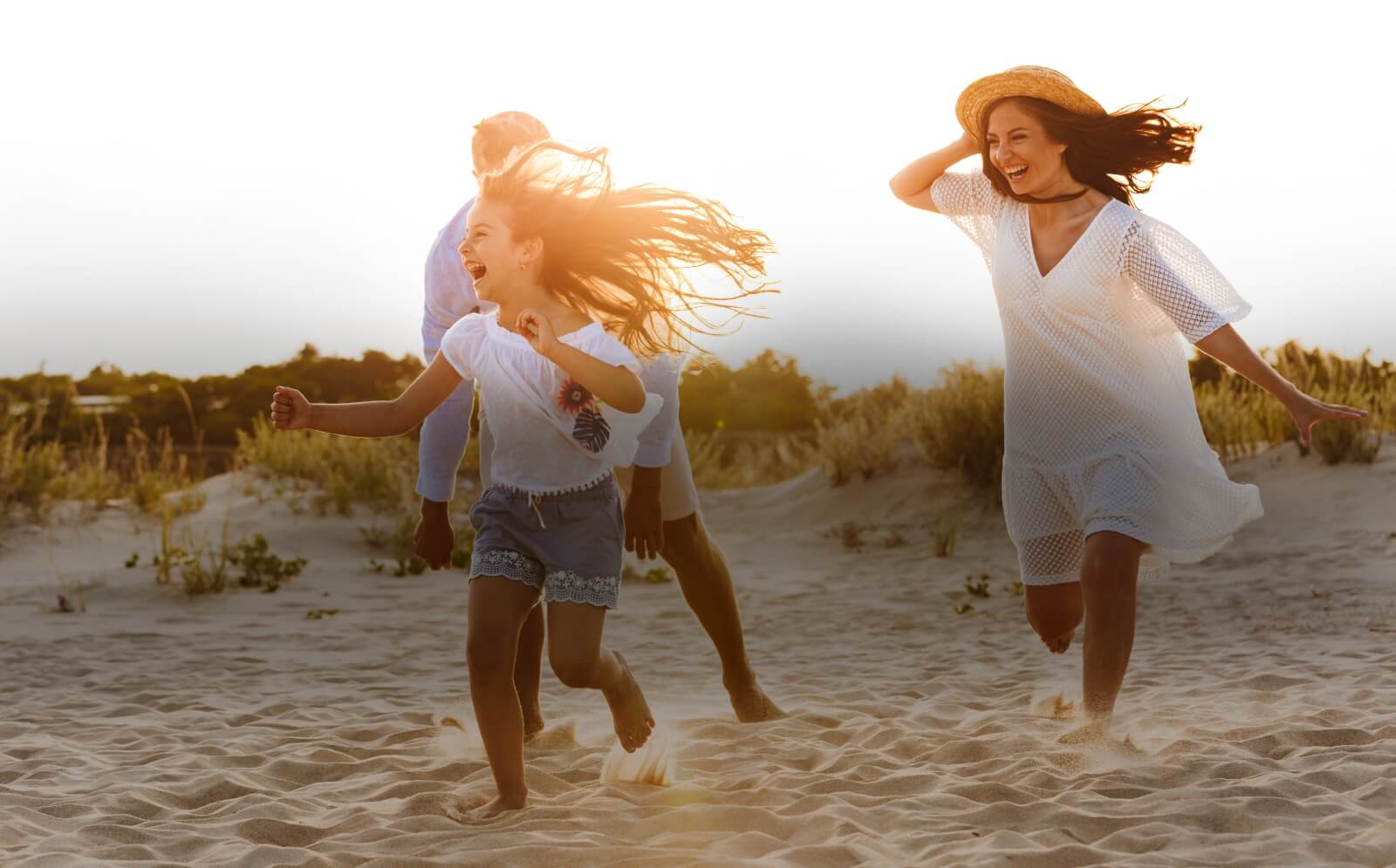 happy family of 3 running on the beach