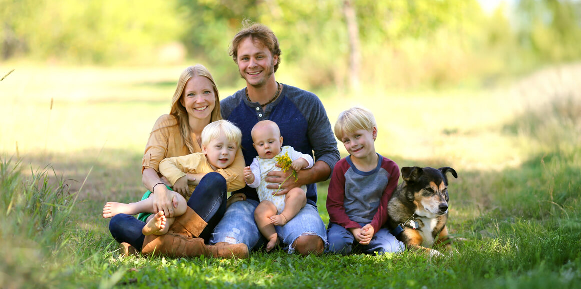 Happy parents with kids sitting outdoors