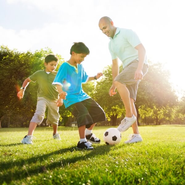 Father and sons playing soccer