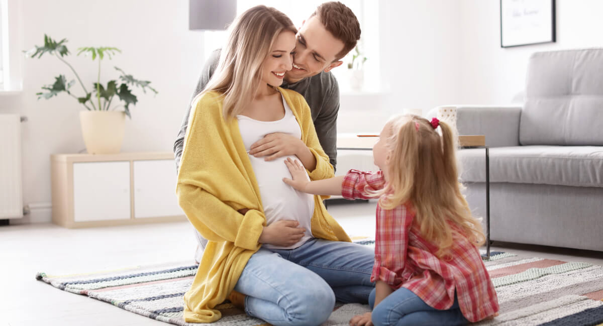 Pregnant mom with her young child and husband