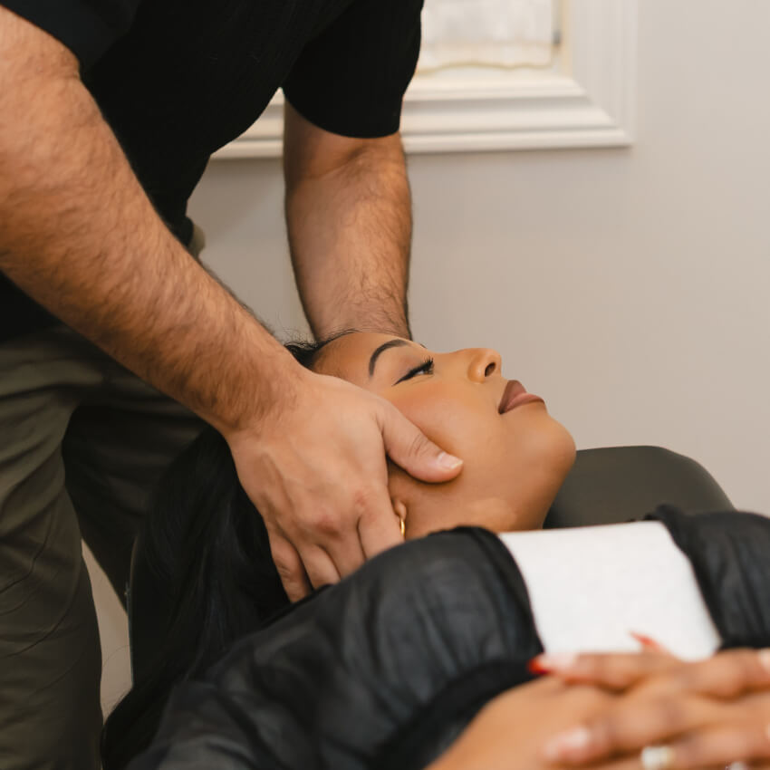 Dr Bali performing a cervical neck adjustment to relieve headaches and migraines