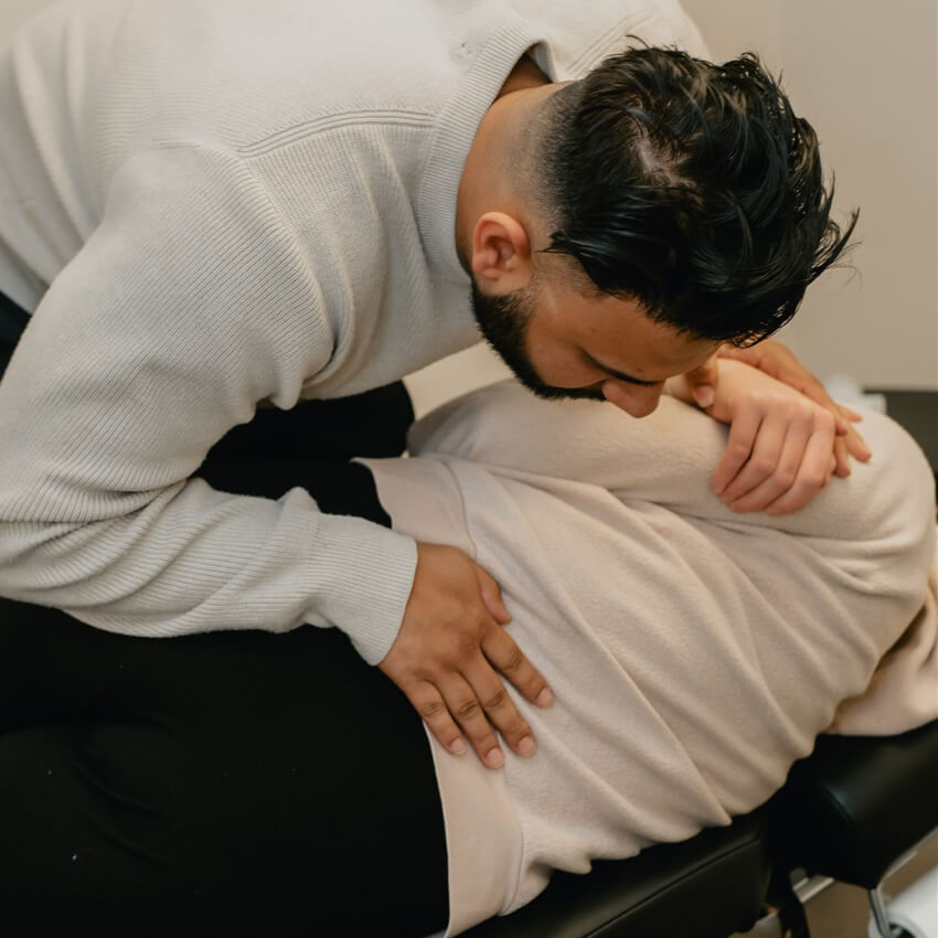 Dr Bali performing a side-posture lower back adjustment for sciatica pain relief