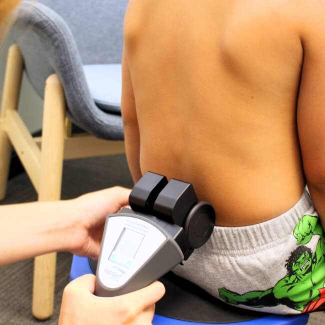 Chiropractic scanning  device used on young boy